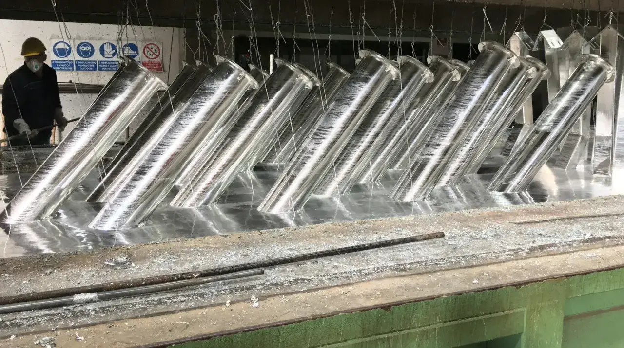 Tubi metallici immersi in un bagno, pronti per la zincatura. La lega di zinco conferirà loro resistenza alla corrosione.