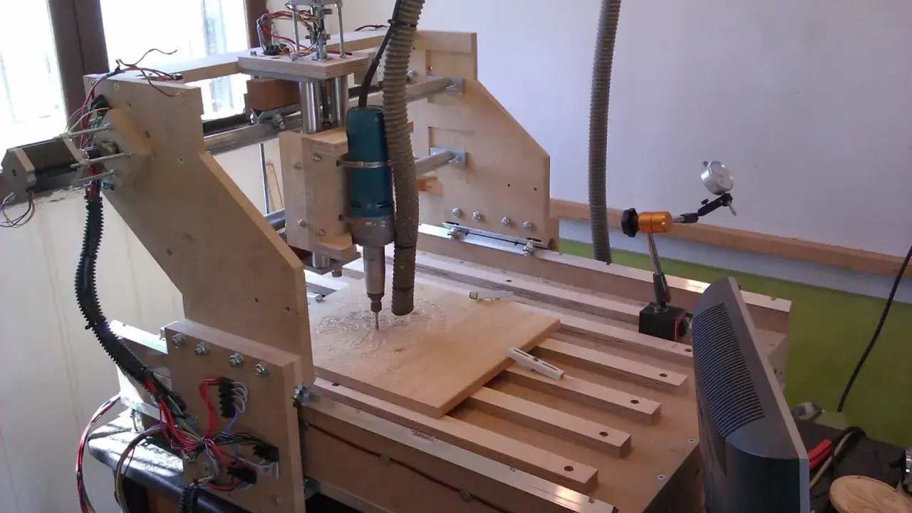 Macchina **cnc fai da te** in legno, con fresa in azione su un pannello.
