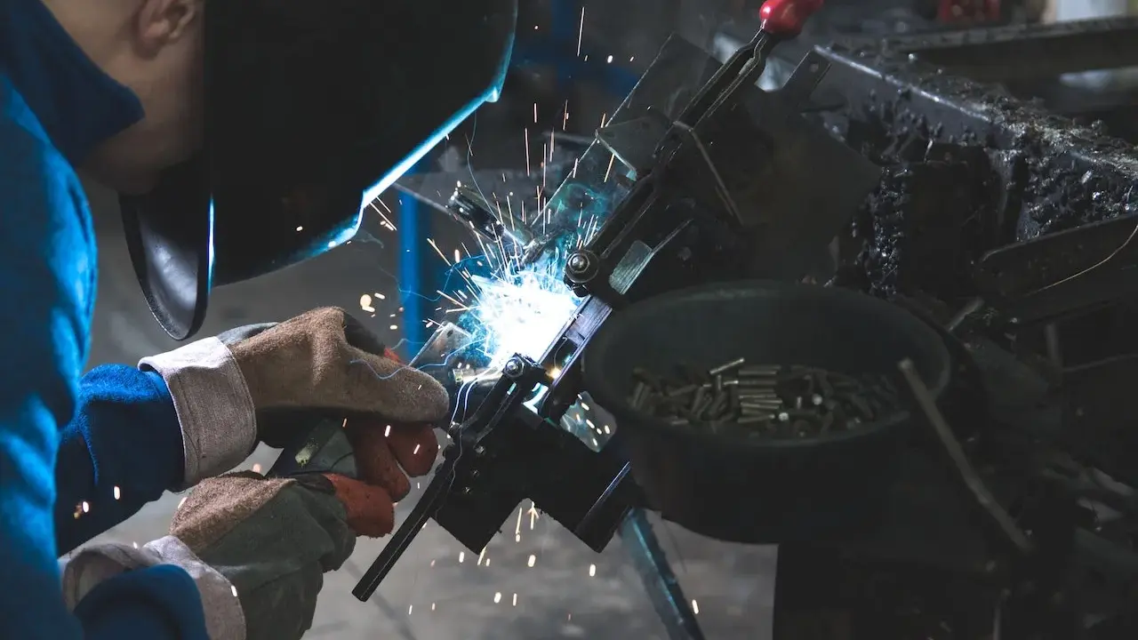 Un attrezzista meccanico al lavoro, con scintille luminose. Lo stipendio di un professionista esperto è meritato.