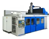 Macchina industriale avanzata, una fresa a 5 assi con pannello di controllo digitale e porte blu brillanti, pronta per lavorazioni complesse.