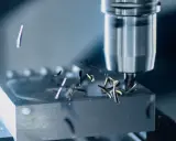 Fresatura di metallo con utensile rotante. Trucioli metallici volano via mentre la programmazione ISO guida la lavorazione di precisione.