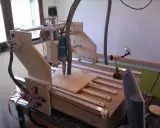 Macchina **cnc fai da te** in legno, con fresa in azione su un pannello.