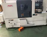 Tornio Mori Seiki NL2500 in officina, con pannello di controllo e pedali arancioni.