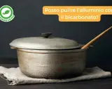 Pentola in alluminio macchiata, con mestolo di legno. Scopri come pulire il metallo con il bicarbonato per un risultato brillante.