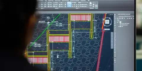 Un ingegnere analizza un progetto di ingegneria civile su AutoCAD, mostrando cos'è questo software per la progettazione.