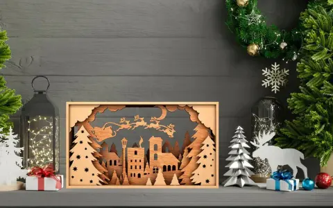 Scena natalizia con Babbo Natale e renne in volo, creata con disegni taglio laser su legno. Un villaggio innevato e alberi completano il quadro.