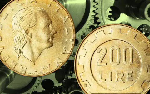 Due monete da 200 lire su ingranaggi metallici. Quanto guadagna un quadro metalmeccanico?