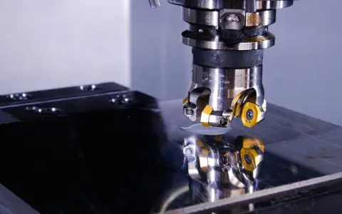 Testa di fresatura su una lastra metallica lucida, riflesso della precisione di un operatore CNC.
