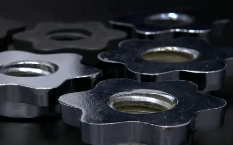 Dettaglio di chiusure a stella in acciaio e nichel, lucide e resistenti, pronte per fissare pesi.