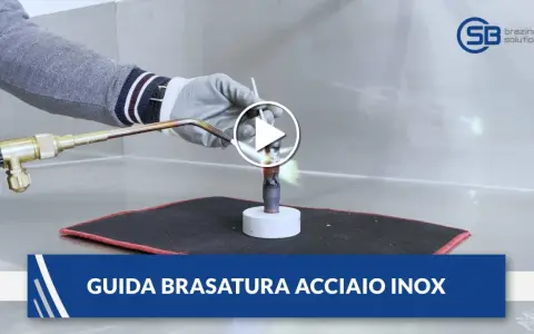 Guida alla brasatura ferro: un operatore con guanti usa una torcia per riscaldare un tubo metallico, mostrando la fiamma viva.