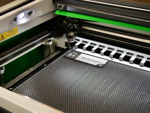 Macchina per taglio laser in azione, che realizza un cartello "Ascenseur" con simboli per bagni. Perfetta per progetti di taglio laser personalizzati.