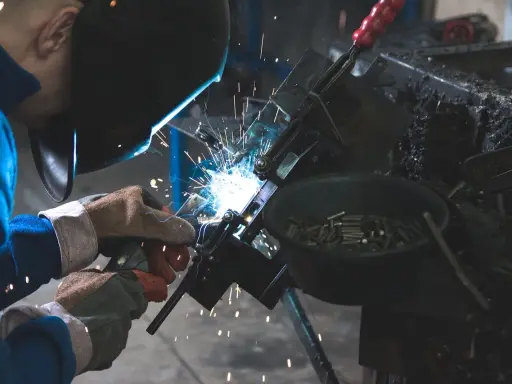 Un attrezzista meccanico al lavoro, con scintille luminose. Lo stipendio di un professionista esperto è meritato.