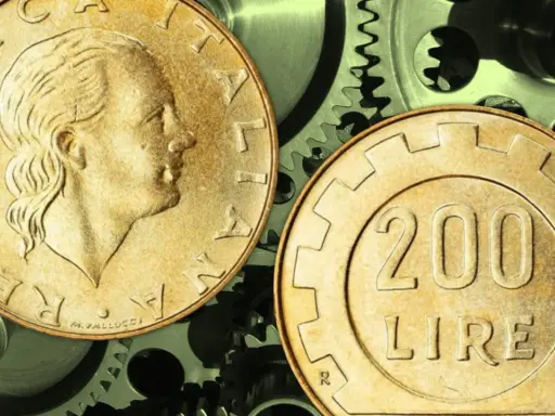 Due monete da 200 lire su ingranaggi metallici. Quanto guadagna un quadro metalmeccanico?