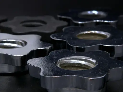 Dettaglio di chiusure a stella in acciaio e nichel, lucide e resistenti, pronte per fissare pesi.