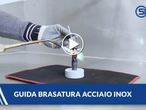 Guida alla brasatura ferro: un operatore con guanti usa una torcia per riscaldare un tubo metallico, mostrando la fiamma viva.