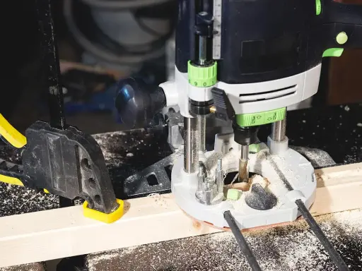 Fresatrice verticale in azione su un pezzo di legno, fissato con morsetto. Guida pratica su come usare fresatrice verticale per lavori precisi.