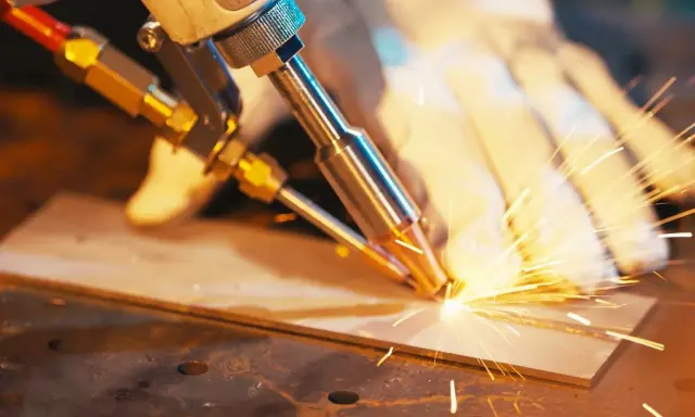 Saldatura di precisione su acciaio, con scintille luminose che danzano nell'aria.