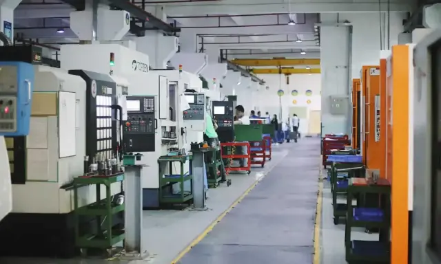 Fabbrica moderna con macchine utensili all'avanguardia, dove operai qualificati creano componenti di precisione.