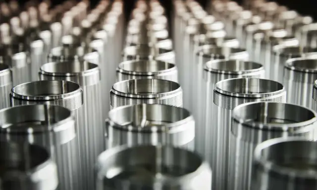 Filettature precise su cilindri metallici. L'alluminio contiene nichel, creando una finitura lucida e resistente.