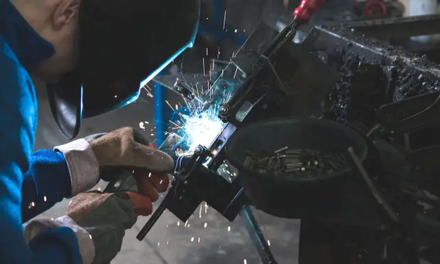 Un attrezzista meccanico al lavoro, con scintille luminose. Lo stipendio di un professionista esperto è meritato.