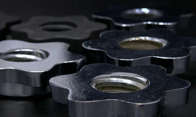 Dettaglio di chiusure a stella in acciaio e nichel, lucide e resistenti, pronte per fissare pesi.