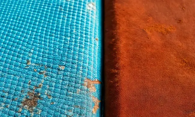 Dettaglio di un test di **salt spray** su due materiali: uno blu con macchie di corrosione, l'altro arancione.