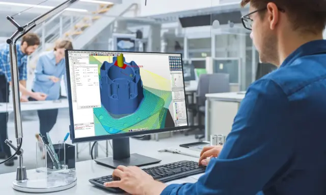 Ingegnere lavora al software cam cnc per progettare un componente meccanico complesso.