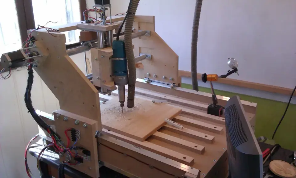 Macchina **cnc fai da te** in legno, con fresa in azione su un pannello.