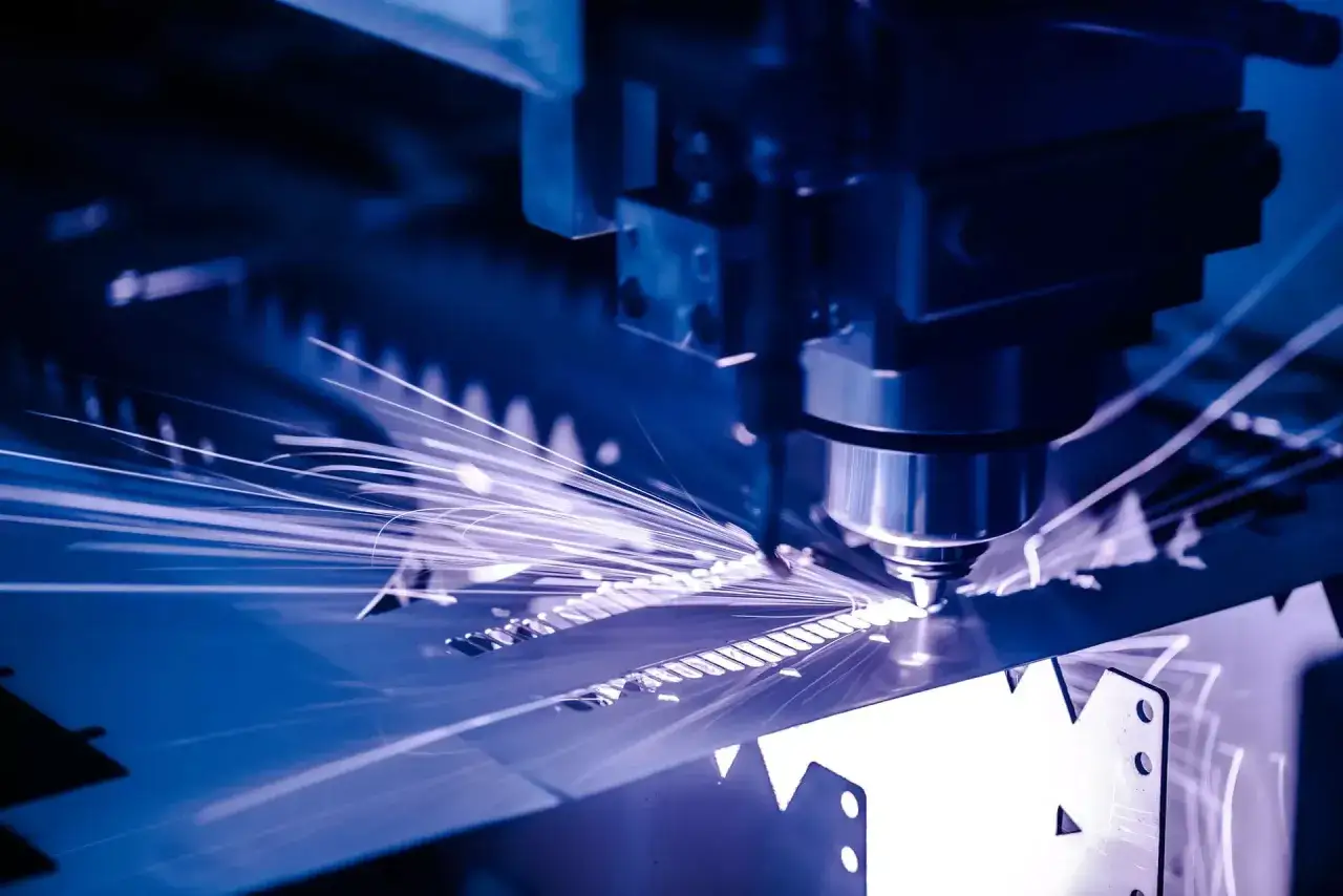 Macchina da taglio laser in azione, scintille luminose danzano mentre il corso CAD prende forma su metallo.