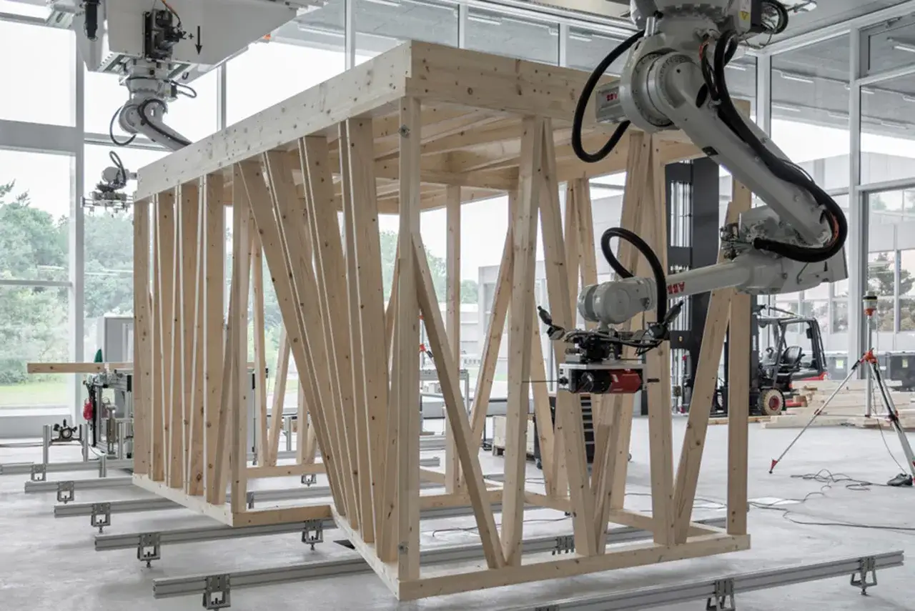 Robot che assemblano una struttura in legno, guidati da software CAD CAM per un'edilizia precisa e automatizzata.