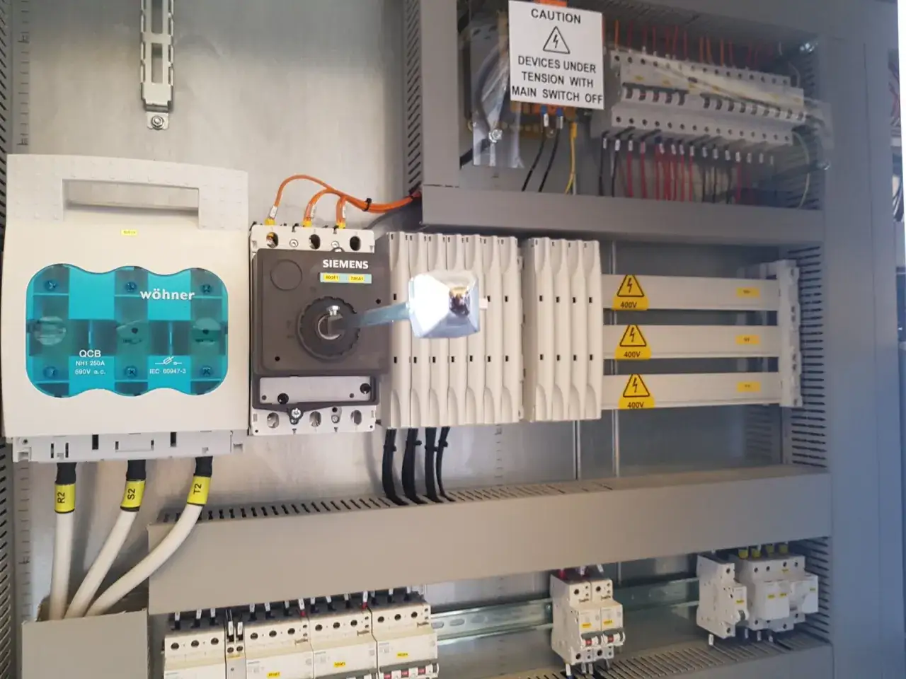 Quadro elettrico con interruttori, sezionatore Siemens e componenti di un programmatore automazione.
