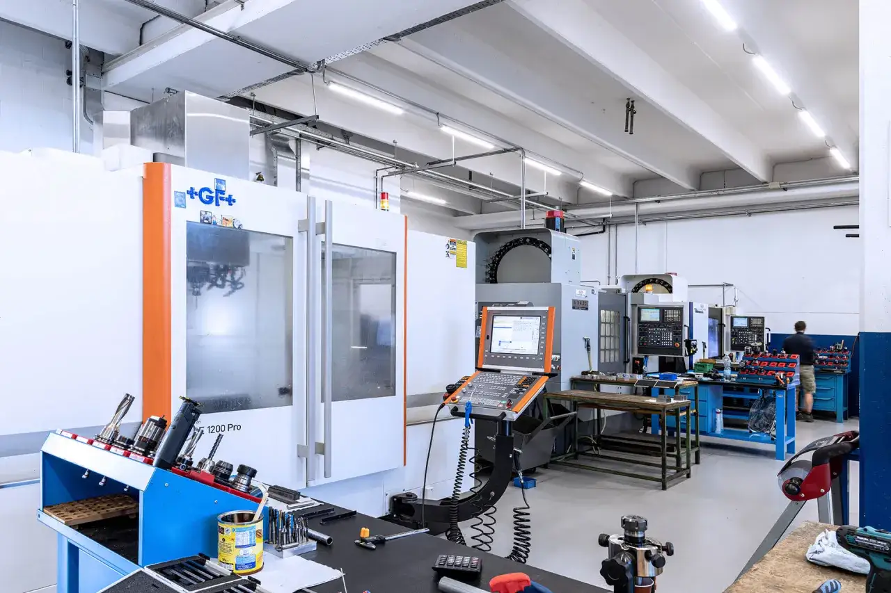 Macchinari per il corso CNC in un'officina moderna. Strumenti e pannelli di controllo visibili.