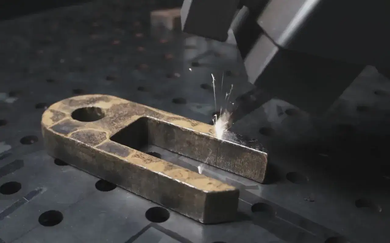 Pulizia laser di un pezzo metallico arrugginito. Scintille indicano il processo di come pulire il metallo.