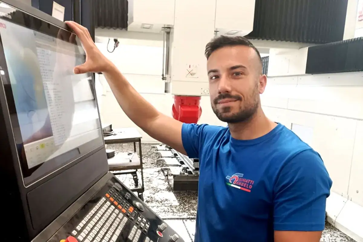 Giovane operatore CNC senza esperienza impara a usare la macchina, toccando lo schermo.