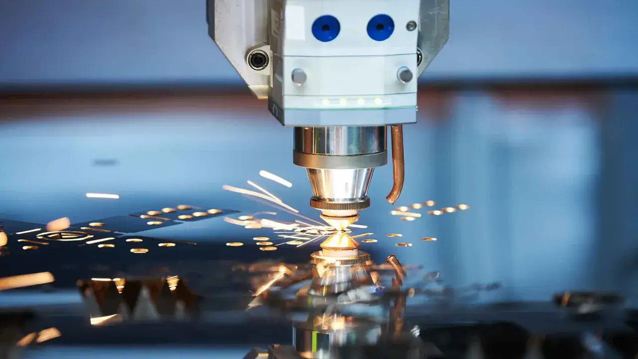 Taglio laser di metallo, con scintille che volano. Il nesting significato è ottimizzare lo spazio per il taglio.