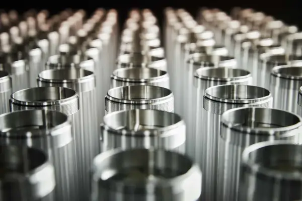 Filettature precise su cilindri metallici. L'alluminio contiene nichel, creando una finitura lucida e resistente.